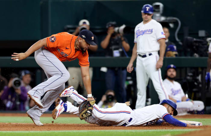 Houston Astros first baseman Jose Abreu, left, tags out Texas Rangers second baseman Marcus Semien for a double play in the fifth inning during Game 4 of the ALCS Thursday night at Globe Life Field.